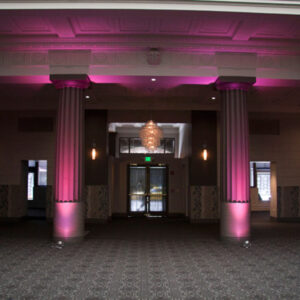 A large room with pink lighting and pillars.