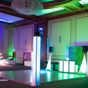 A large ballroom with a stage, lights, and a Denver DJ.