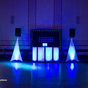 A dj set up in a room with blue lights for a bar mitzvah.