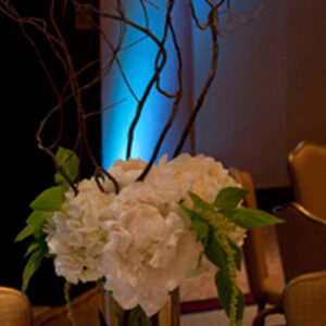 A gold vase with white flowers in it.