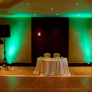 A room with green lighting and a table and chairs.
