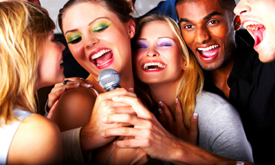 A group of people singing into a microphone at birthday parties.