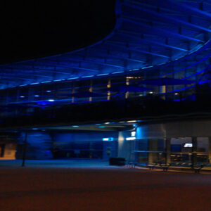 A blue lit building at night.