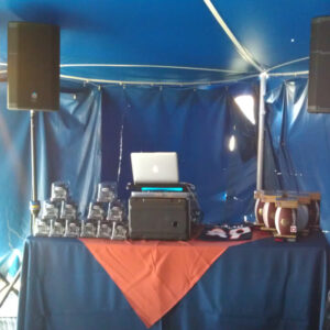 A dj set up under a blue tent.