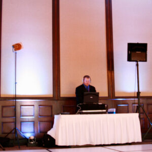 A man standing in front of a set of speakers.