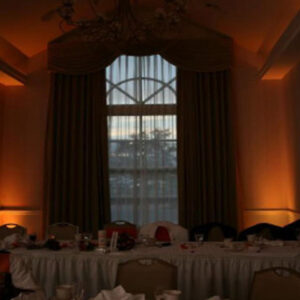 A room with a table and chairs in front of a window.