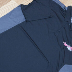 A black and grey polo shirt, an apparel, on a wooden floor.