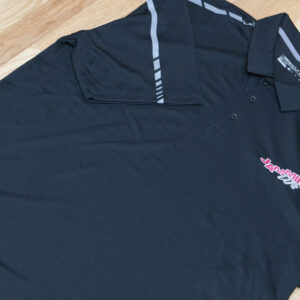 A black polo shirt on a wooden floor, showcasing apparel.