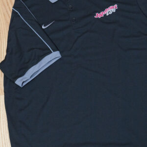 Apparel: A black Nike polo shirt displayed on a wooden floor.