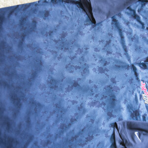 An apparel nike polo shirt with a camouflage pattern.