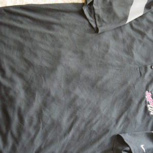 A black polo shirt with a pink logo on it, perfect for apparel.