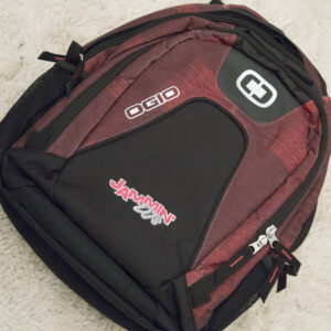 A red and black apparel sitting on a rug.