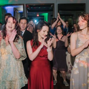 A group of people clapping at a wedding reception.