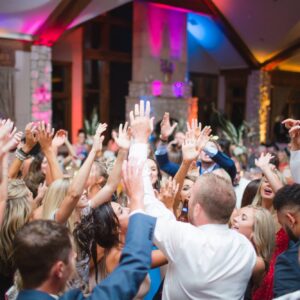 A group of people dancing at a wedding reception.