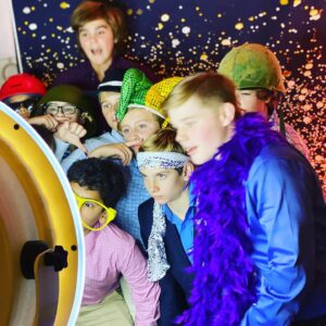 A group of people posing for pictures in a photo booth at a Bat Mitzvah.