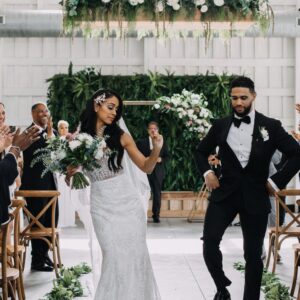A bride and groom walking down the aisle at a wedding ceremony.