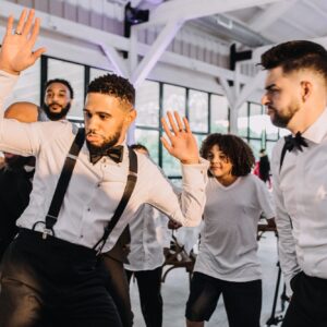 A group of men dancing at a wedding reception.