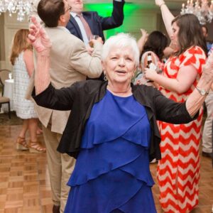 An older woman dancing at a wedding reception.