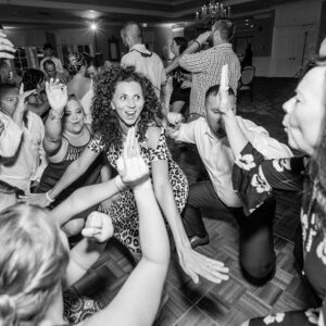 A live group of people dancing on the dance floor at a wedding.