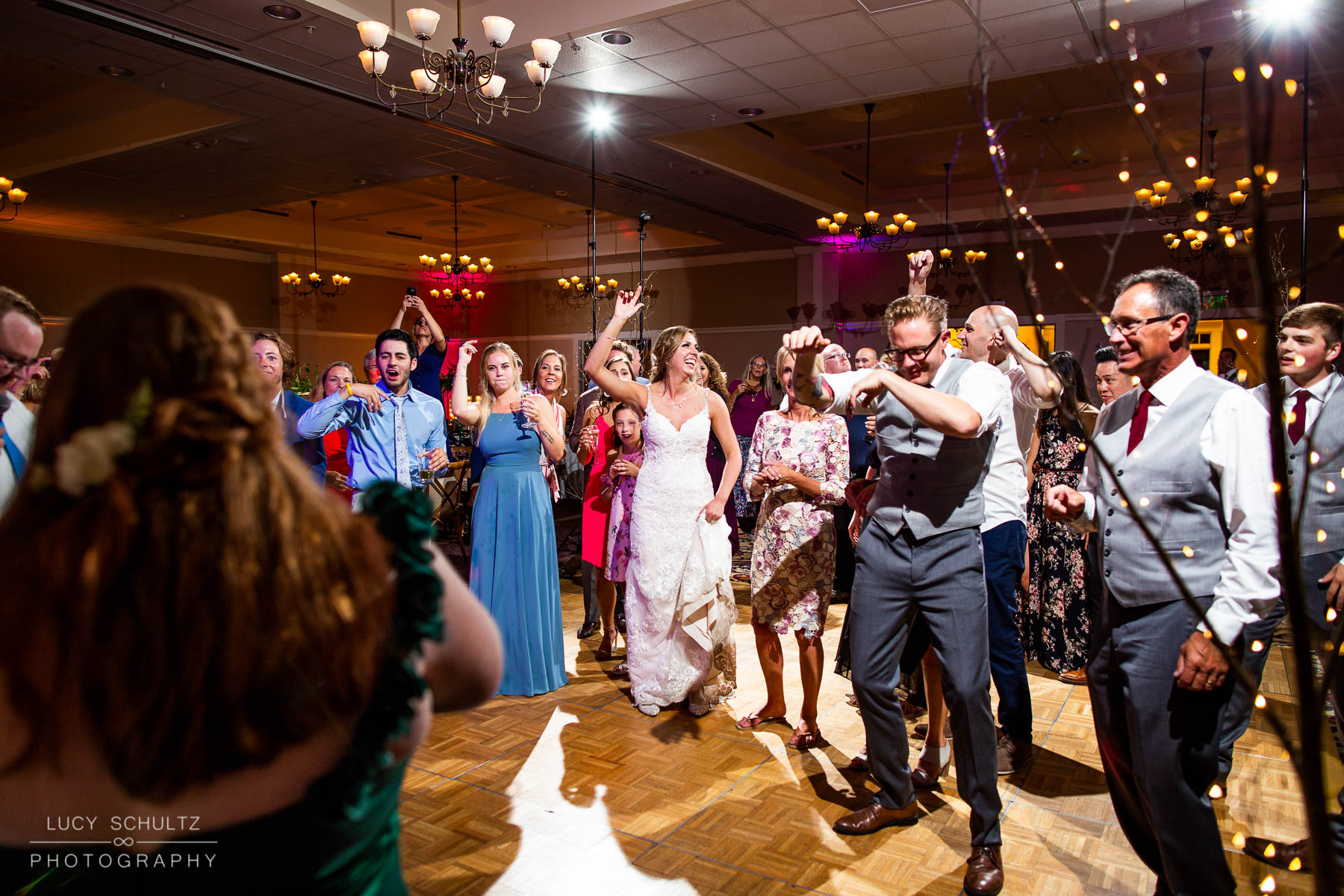 A group of people dancing at a wedding reception.