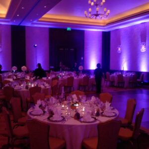 A banquet room with purple lighting and tables.