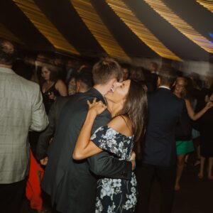 A couple kissing at a wedding reception.