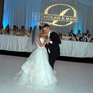 A bride and groom gracefully twirling on the dance floor under the expert guidance of a DJ.