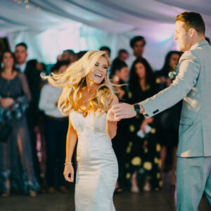 A bride and groom dancing at their wedding reception, entertained by a professional DJ service.