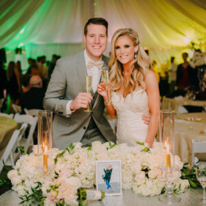A bride and groom posing for a photo at their wedding reception, with a Denver DJ playing in the background.