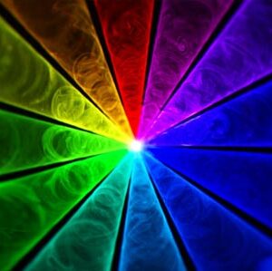 An image of a rainbow colored light over DJ equipment.