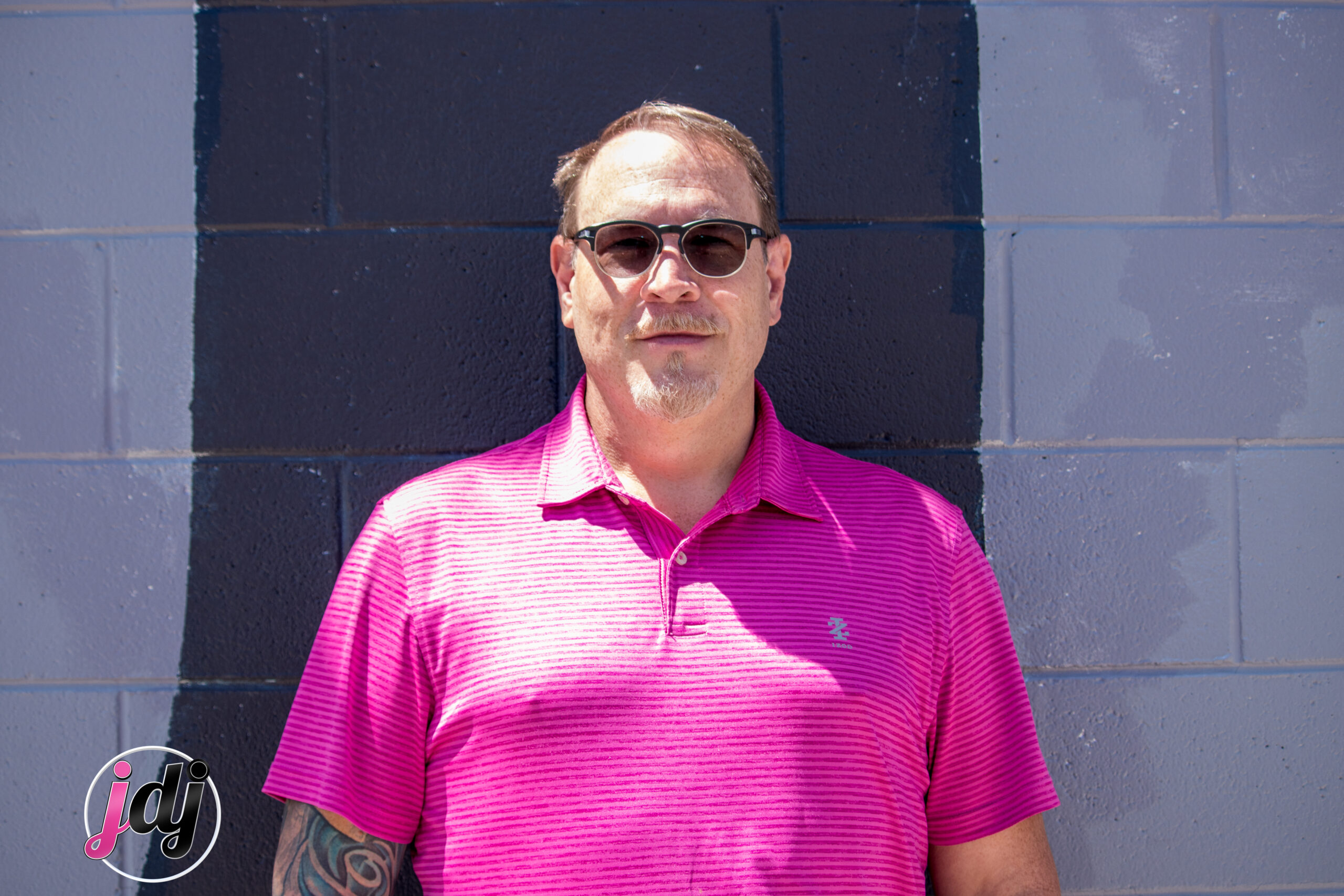 A man wearing a pink shirt at a bar mitzvah.
