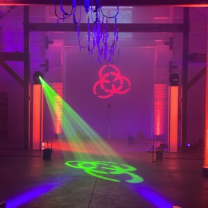 A stage with colorful lights and a chandelier for a bar mitzvah.