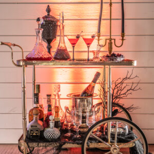 A cart with bottles and glasses on it, perfect for a bar mitzvah celebration.
