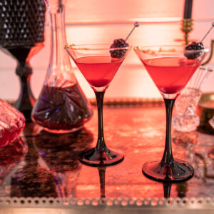 Two glasses of red wine on a table at a Denver DJ event.
