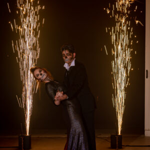A man and woman dancing in front of sparklers at a wedding DJ service.