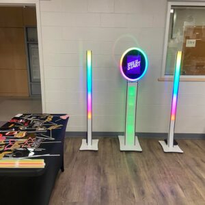 A room with several colorful lights and a table, set for a bar mitzvah.
