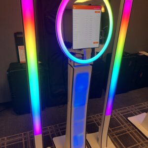 A wedding DJ light stand with a rainbow colored light on it.