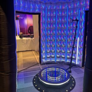 A room with a blue light in the middle of it, setup for a wedding DJ.