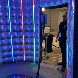 A man standing in front of an inflatable room at a bar mitzvah.