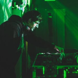 A wedding DJ playing music in front of a green screen.
