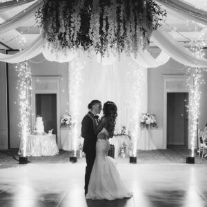 A bride and groom share their first dance in a black and white photo, enhanced by the DJ service providing music in the background.