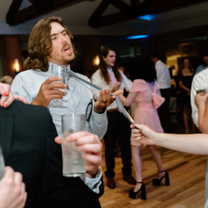 A group of people at a wedding, including the wedding DJ.