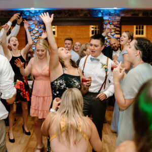 A group of people dancing at a wedding reception, energized by the Denver DJ.