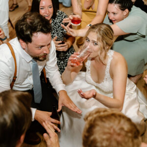 A bride and groom having a drink at a wedding reception, enjoying music from their Denver DJ.