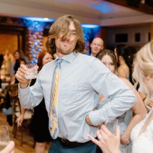 A man dancing on the dance floor at a Denver DJ service during a wedding reception.