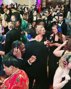 A group of people wearing headphones at a wedding DJ party.