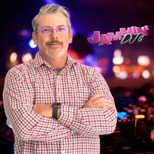 A man standing in front of a dj booth at a bar mitzvah.