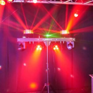 Stage lights with red and green beams crossing in a dark venue, part of the DJ equipment, mounted on a stand with the label "gigbar move.