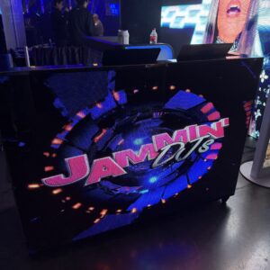 DJ booth with a digital display showing the text "Jammin' DJs" in a vibrant, colorful design.