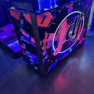 A DJ booth with a vibrant LED display featuring the letters "jdj" in a colorful, dynamic pattern.